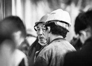 Black-and-white portrait of a construction worker wearing a hard hat